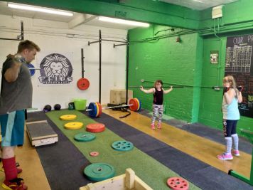 Pride Warrington Cub's Child Class members practicing their olympic weightlifting technique